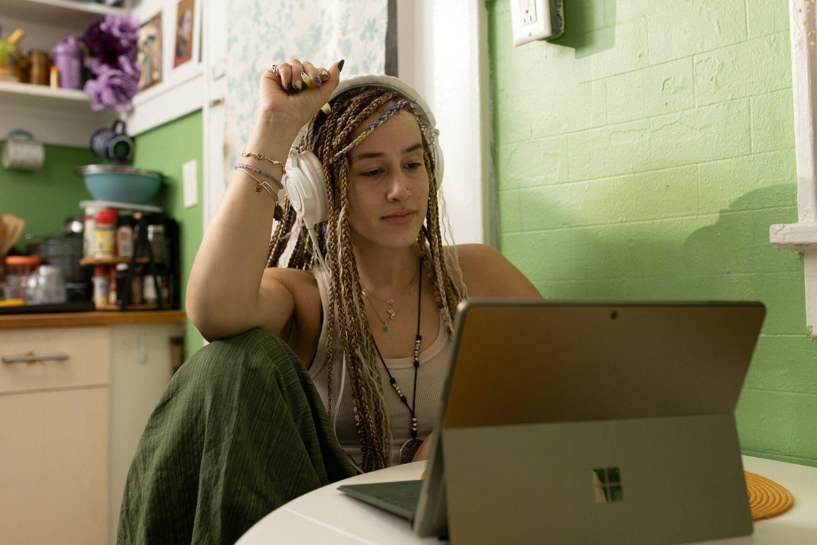 a woman with dreadlocks sitting in front of a laptop computer